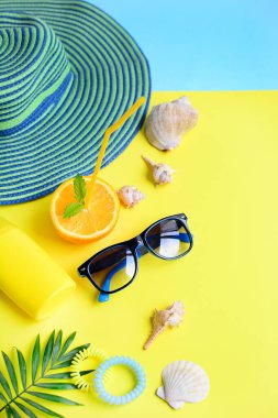 Plaj tatili için dikey bileşimler, deniz kabukları, sarı arka planda palmiye dalları. Kapat..