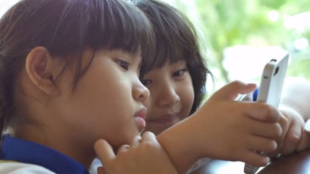 4K : Gros plan de l'enfant asiatique jouant au jeu sur téléphone intelligent ensemble — Video