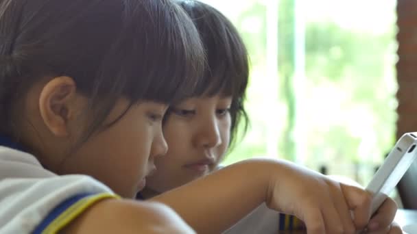 4K: Close up de criança asiática jogando jogo no telefone inteligente juntos — Vídeo de Stock