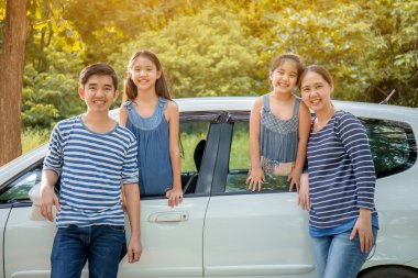 Asya ailesiyle mutlu: mini van gülümseyerek ve yaz seyahat için hazırlanıyor