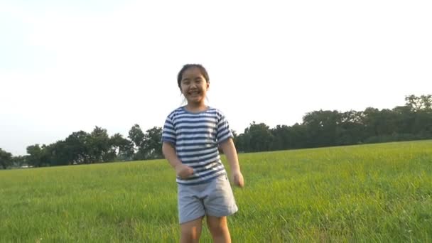 Slow motion shot : Joyeux asiatique petite fille chantant et dansant dans le parc — Video