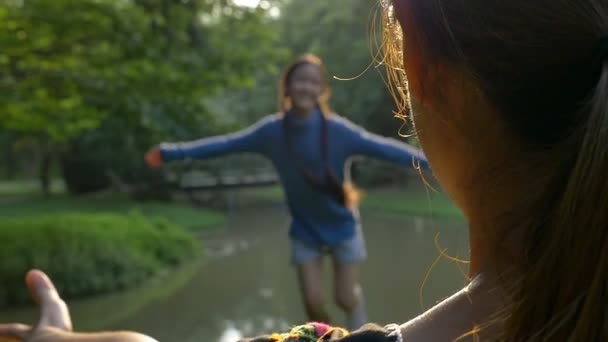 Bella ragazza asiatica in esecuzione per la sua mamma che la abbraccia con affetto, Slow motion shot — Video Stock
