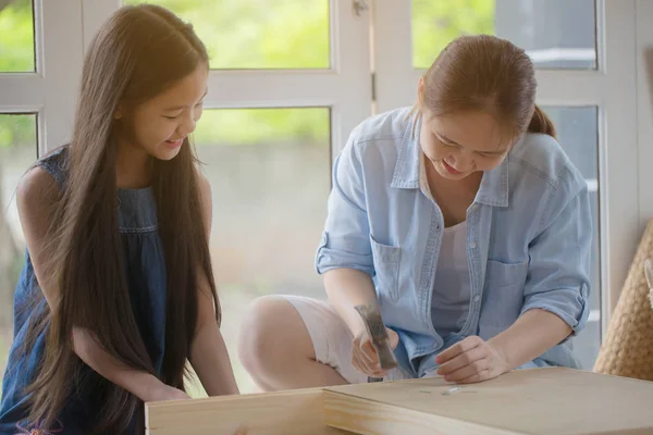 Asiatisk härlig flicka att hjälpa mamman montering nya Diy möbler hemma tillsammans — Stockfoto