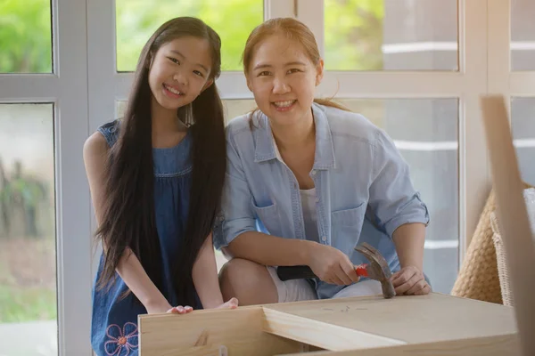 Asiatique belle fille aider sa mère à assembler de nouveaux meubles bricolage à la maison ensemble — Photo