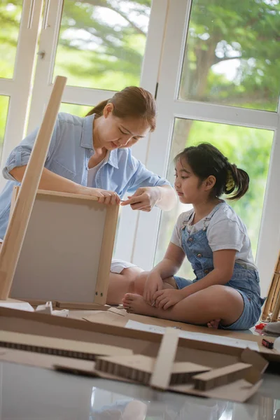 Asiatisk kvinna undervisning dottern montering nya Diy möbler hemma — Stockfoto