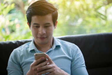 Küçük Asya adam dinleme müzik akıllı telefon Cafe