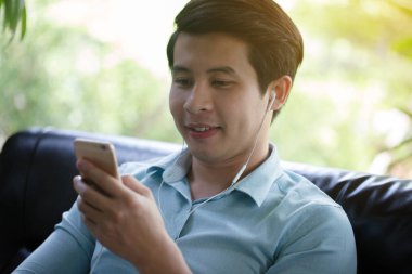 Küçük Asya adam dinleme müzik akıllı telefon Cafe