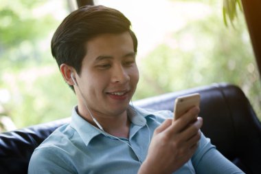 Küçük Asya adam dinleme müzik akıllı telefon Cafe