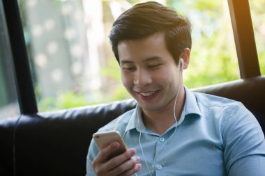 Küçük Asya adam dinleme müzik akıllı telefon Cafe