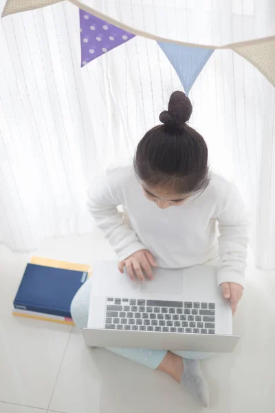 Asiatique fille à l'aide d'un ordinateur portable dans la chambre à coucher décorer avec drapeau parti triangle pastel — Photo