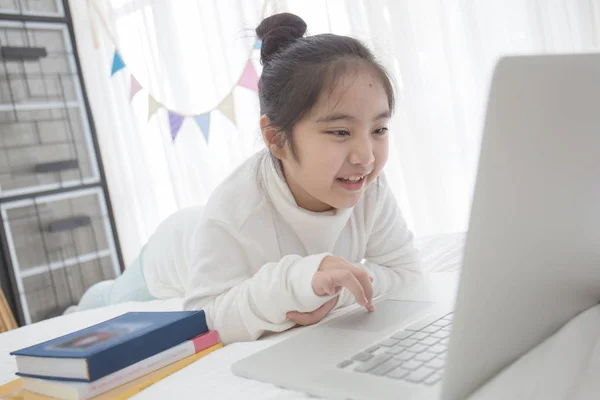 Asiatique fille à l'aide d'un ordinateur portable dans la chambre à coucher décorer avec drapeau parti triangle pastel — Photo