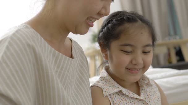 4K: Movimento lento de mãe asiática feliz e filha brincando com tablet digital juntos em casa — Vídeo de Stock