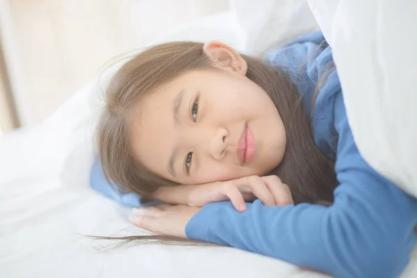 快乐的亚洲女孩躺在床上与阳光慵懒的一天 — 图库照片