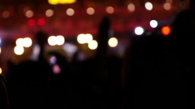 Konser kalabalığın önünde parlak sahne ışıkları Asya, yavaş çekim bulanık siluetleri