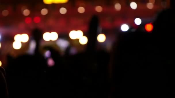 Siluetas borrosas de la multitud de conciertos frente a luces de escenario brillantes en Asia, disparo en cámara lenta — Vídeo de stock