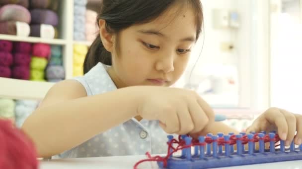 4K: Close up de prática menina asiática para tricô — Vídeo de Stock