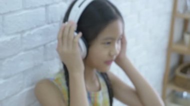4k: çekici Asyalı kız odasında kulaklık ile müzik dinleme