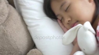 4k: Asyalı kız yatakta bebek uyku