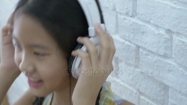4k: çekici Asyalı kız odasında kulaklık ile müzik dinleme
