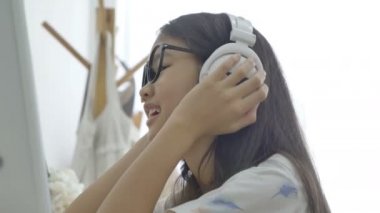 4k: çekici Asyalı kız odasında kulaklık ile müzik dinleme