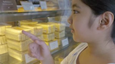 4k: Asyalı kız ile farklı kek görüntü penceresine bakarak