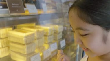 4k: Asyalı kız ile farklı kek görüntü penceresine bakarak