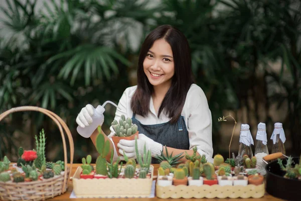 肖像画若いアジアの女の子の小さなサボテンを鍋に植える — ストック写真