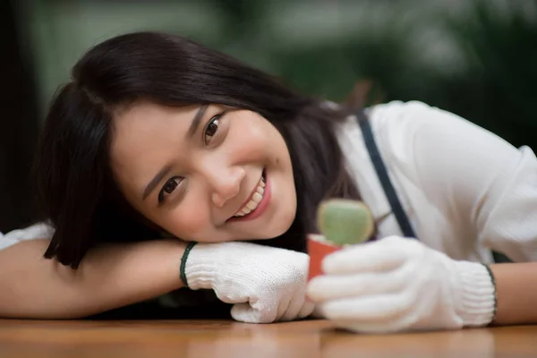 Porträt junge asiatische Mädchen mit kleinen Kaktus in einem Topf — Stockfoto