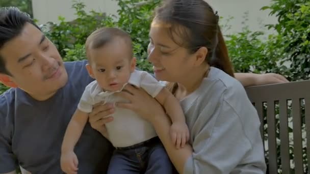 Slow motion van gelukkig Aziatische baby met zijn vader en moeder spelen samen in het park — Stockvideo