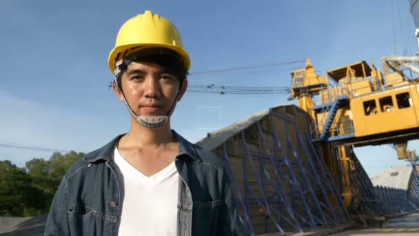 4k: Slow motion van Aziatische ingenieur op bouwplaats met blauwe lucht — Stockvideo