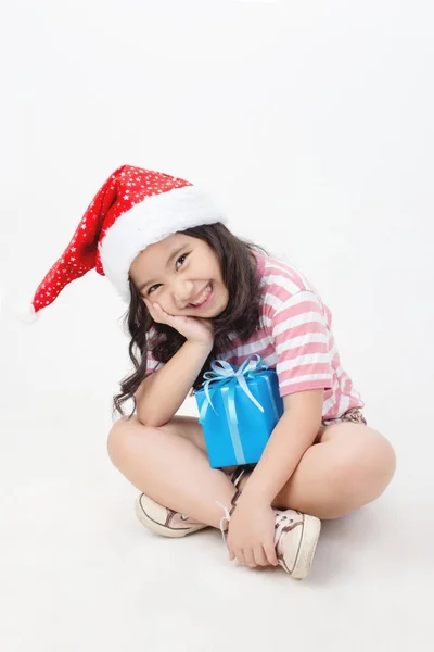 Little Asian girl in Santa hat and blue gift box isolated — Stock Photo, Image