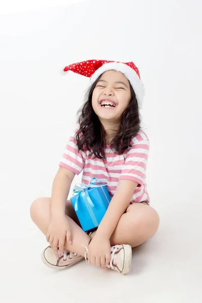 Liten asiatisk flicka i Santa hatt och blå presentask isolerade — Stockfoto