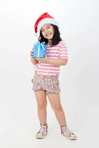 小亚洲女孩在圣诞老人帽子和蓝色礼物箱子隔绝了 — 图库照片