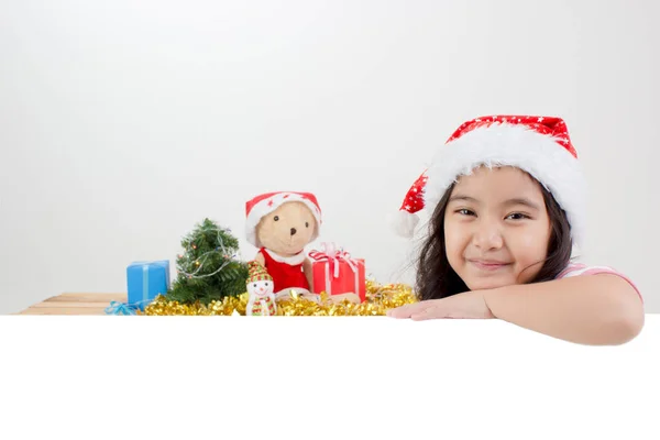 Happy Asian child in Santa hat holding white board with Christma — Stock Photo, Image