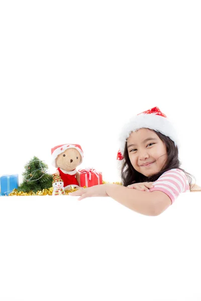 愉快的亚洲孩子在圣诞老人帽子藏品白色板与圣诞 — 图库照片