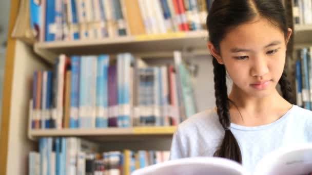 Ασιάτισσα Φοιτήτρια Διαβάζοντας Ένα Βιβλίο Στη Βιβλιοθήκη Του Σχολείου Για — Αρχείο Βίντεο