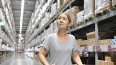 alışveriş sepeti ambar yoluyla, yeni mobilya seçimi 4 k yavaş hareket Asyalı kadın sürmek