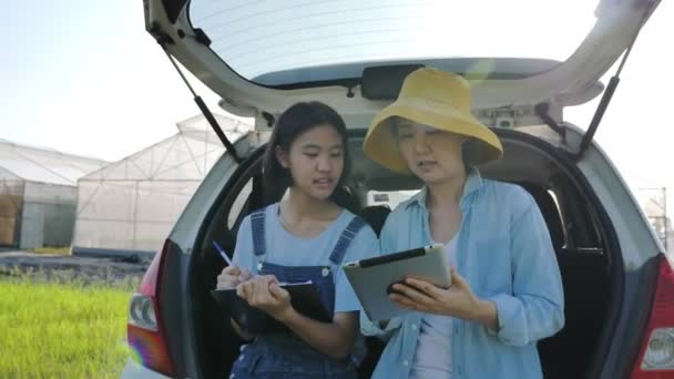 スマートアジアの家族は車の上に座って 緑の家のインターネットアクセスのためのデジタルタブレットを使用して スマート農業の概念 — ストック動画