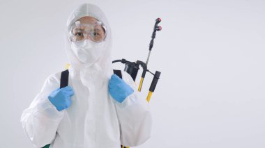 PPE kıyafeti giyen Asyalı viroloji bilimcileri mikropları temizlemek için kimyasal malzeme kullanıyorlar.