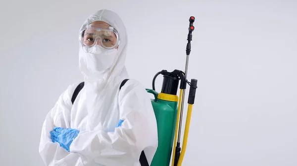 Asian virology scientists wearing PPE suit and using chemical equipment to spray for clean up germs