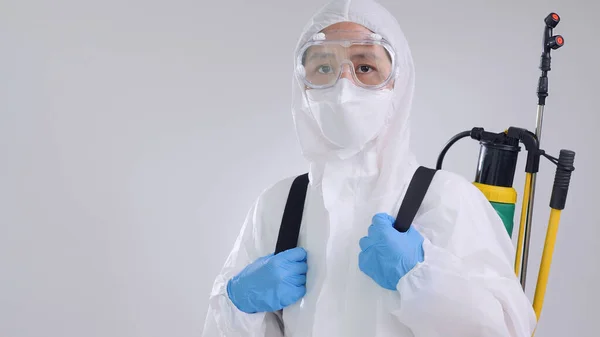 Ppeスーツを着用し 細菌をきれいにスプレーするために化学装置を使用してアジアのウイルス学者 — ストック写真