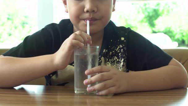 Jeune asiatique enfant boire un verre d'eau  . — Video