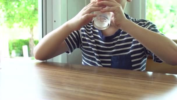 Jeune asiatique enfant boire un verre d'eau  . — Video