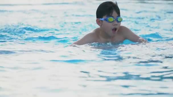 Mouvement lent du jeune garçon asiatique s'amusant à la piscine, enfant asiatique heureux jouant dans la piscine . — Video