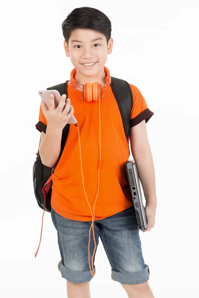 Szczęśliwy chłopiec azjatyckich za pomocą telefonów komórkowych i trzymając laptop . — Zdjęcie stockowe