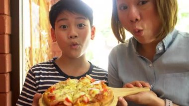Küçük Asyalı çocuk beslenme Pizza'da Restoran .happy Asyalı çocuk Afiyet olsun.