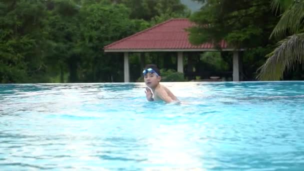 Повільному молодих азіатських хлопчика весело біля басейну, щасливі азіатських дитина грав в басейн. — стокове відео