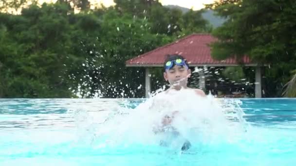 Slow motion av unga asiatiska pojke att ha kul på pool, gärna asiatiska barn som leker i poolen. — Stockvideo