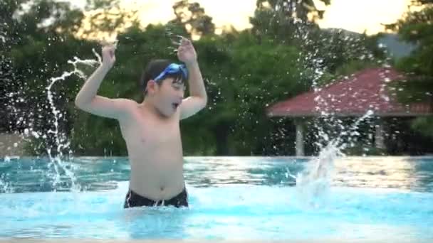 Cámara lenta de joven asiático chico tener divertido en piscina feliz asiático niño jugando en piscina . — Vídeos de Stock