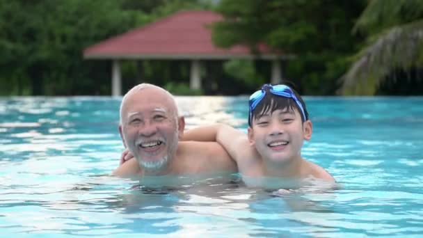 Slow motion van Aziatische en gelukkige familie spelen in zwembad, Aziatische kleinkinderen en groot ouders zwemmen in zwembad. — Stockvideo